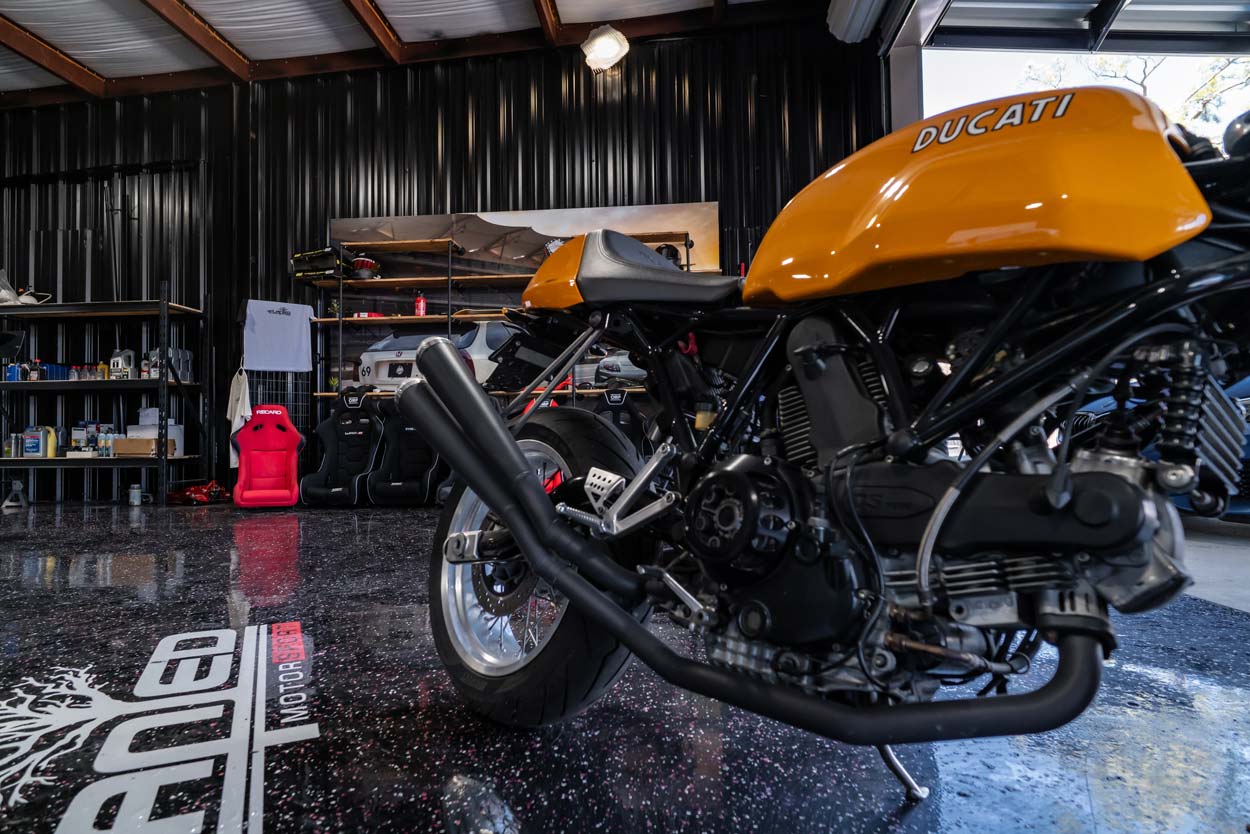 Ducati motorcycle with a custom exhaust inside the shop