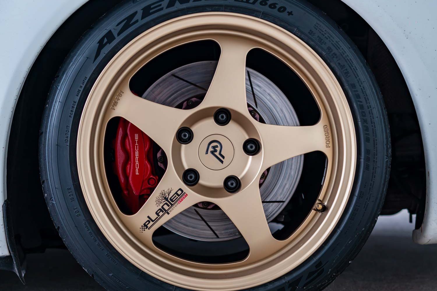 Gold PM-01 forged wheel fitted on a white car