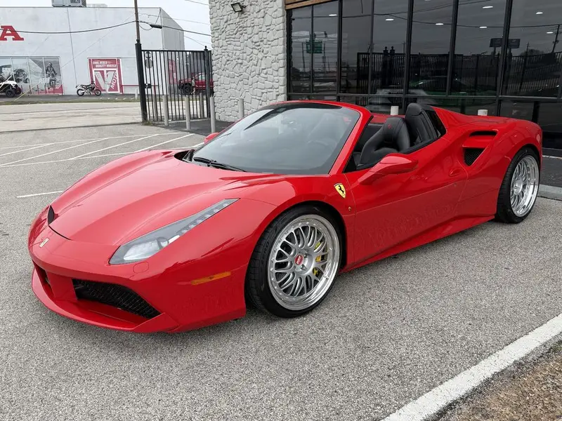 Red Ferrari 488 Spider with silver wheels parked in the sun